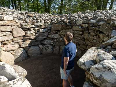 Man exploring the ancient site of the Clava Cairns