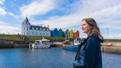 Woman enjoying sea views from the harbour at John O'Groats