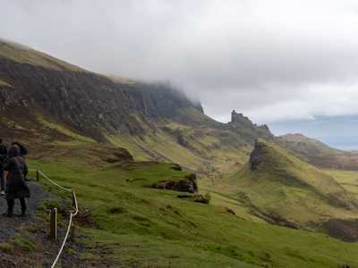 Group of travellers enjoying walk among scenic Quiraing on Isle of Skye