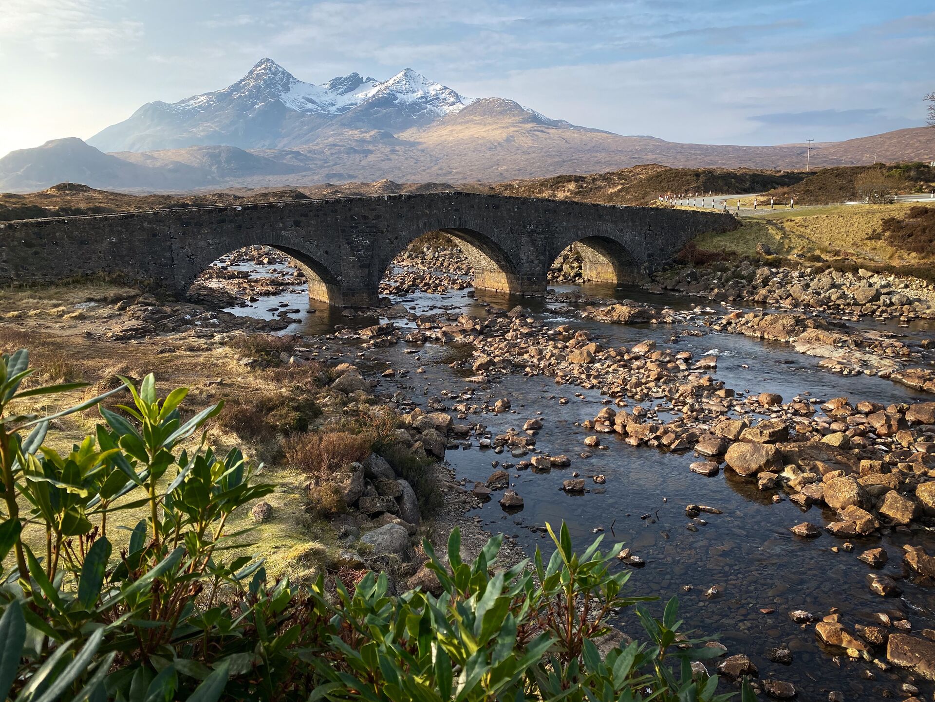 Sligachan Bridge over frosty rivers and snow-capped mountain backdrop on Isle of Skye