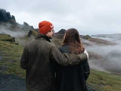 Young couple takign in views of the misty Quiraing Mountains in Scotland on Isle of Skye