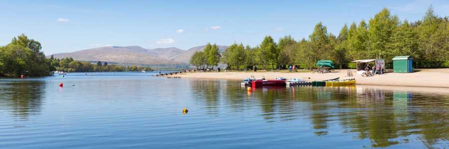 Peaceful and sansy shores of Balloch in Loch Lomond on a clear afternoon