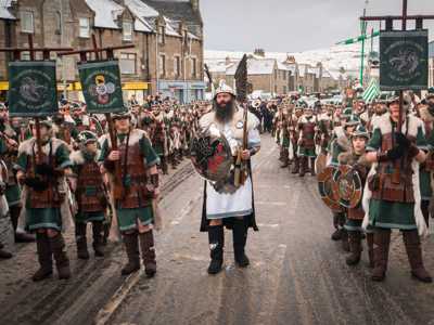 Up Helly Aa Viking parade in Lerwick with the Jarl and squad in detailed Viking attire, carrying shields and flags