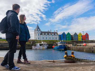Couple exploring the harbour of John O'Groats