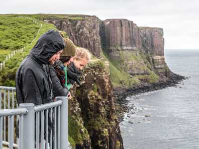 Three travellers standing on the viewing platform at the Kilt Rock cliffs