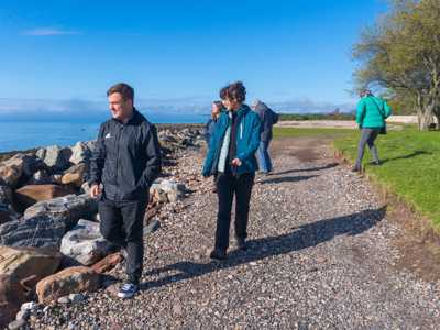 Travellers walking along the coast near Dunrobin Castle Beach