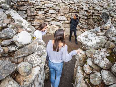 Two young women standing inside the Clava Cairns burial circle